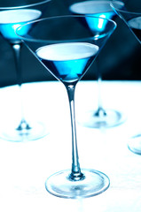 Dazzling blue martini vodka gin cocktails on silver tray at nightclub