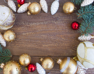 Christmas or New Year background: fur-tree branches, colorful glass balls, decoration and glittering stars on  wood background