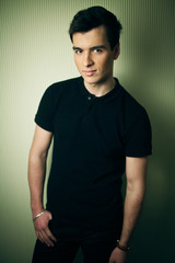 Man dressed in casual style poses before the wall