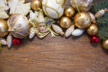 Christmas or New Year background: fur-tree branches, colorful glass balls, decoration and glittering stars on  wood background