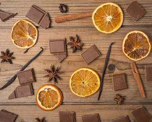 chocolate with cinnamon, orange and vanilla on wooden table