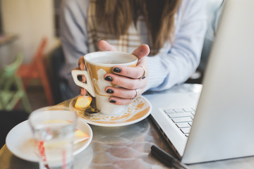 Close up on the hand of young woman holding a mug of hot tea - autumn, relaxing concept