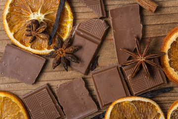 chocolate with cinnamon, orange and vanilla on wooden table
