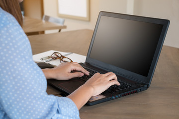 Naklejka premium Preview Save to a lightbox Find Similar Images Share Edit Stock Photo: Woman using laptop on tablet on wooden table in coffee shop with a cup of coffee.