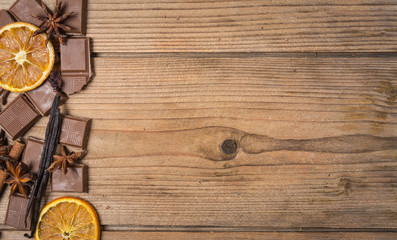 chocolate with cinnamon, orange and vanilla on wooden table