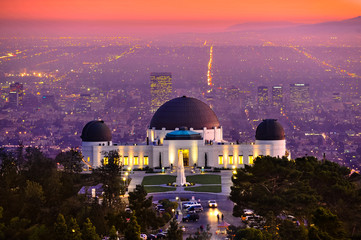 Historic famous Griffith Park Observatory at Sunset with Los Angeles city lights sparkling in...