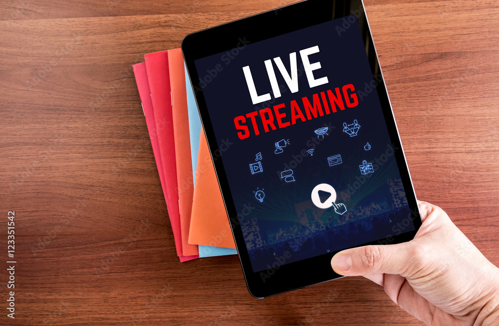 Poster top view of hand holding tablet with live steaming word with ico