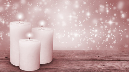 three candle lights with red festive winter background