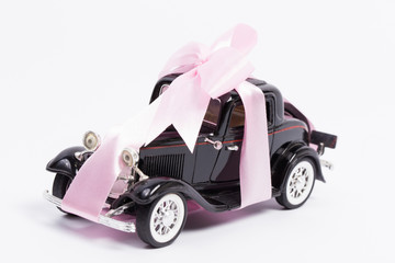 Toy car wrapped in a pink ribbon
