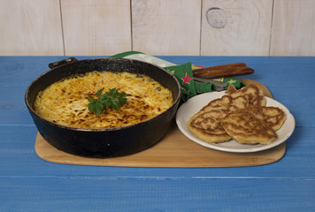 Блюдо из кабачков на голубом столе.