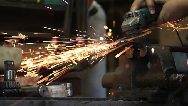 Worker cutting metal with a grinder