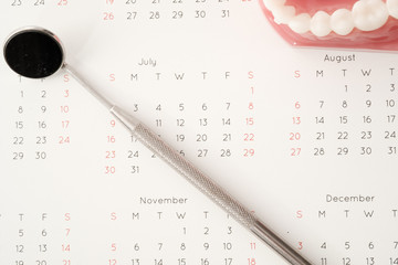 Dentist tool and demonstration teeth model on calendar
