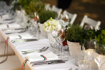 Sparkling forks and knives lie on white dinner table decorated w