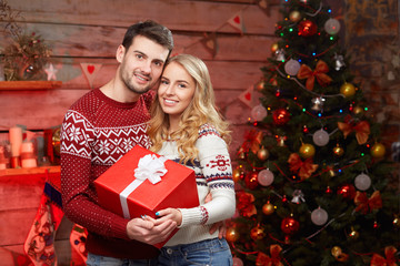 Nice stylish loving couple near Christmas tree