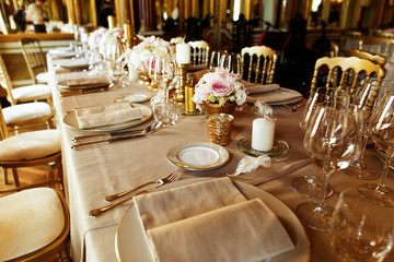 Flax serviettes lie on the plates standing among shiny glassware