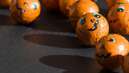 Halloween sweets with cute faces and shadows.