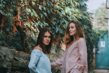 Two young beautiful girls walking and talking