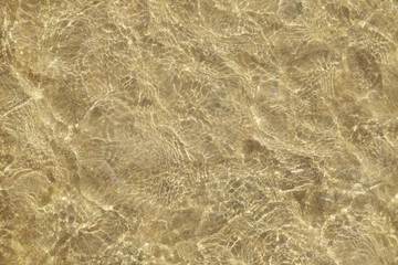 A full page of shallow sea water rippling over a white sand beach background texture