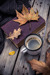 Old book, knitted sweater with autumn leaves and coffee mug