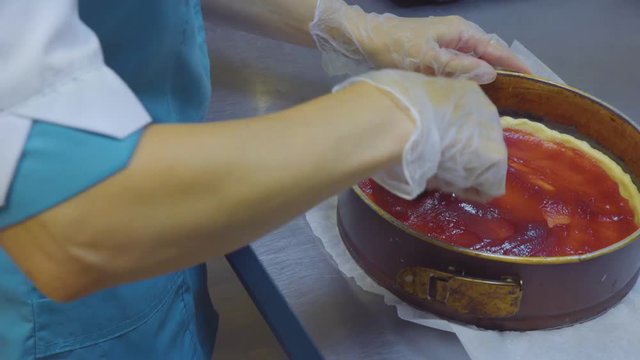 A woman making a delicious fresh apple pie in her kitchen