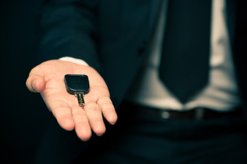 Businessman in suit giving a key