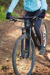 Fototapeta na wymiar Female mountain biker riding bicycle in the forest
