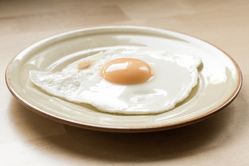 Fried egg on plate on kitchen table