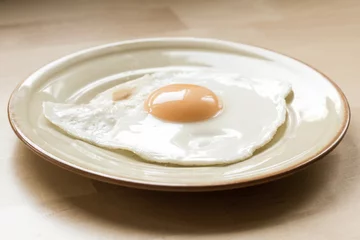Papier Peint photo Oeufs sur le plat Fried egg on plate on kitchen table