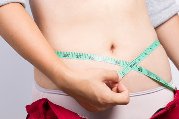 Woman measuring her waist