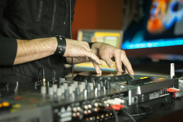 Hands of a DJ playing music at a party