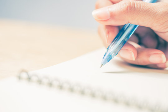 Business women hands working writing notebook on wooden desk, lighing effect