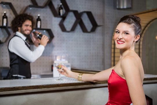 Portrait of beautiful woman standing at bar counter