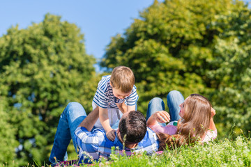 Familie spielt mit Kind im Gras auf der Wiese