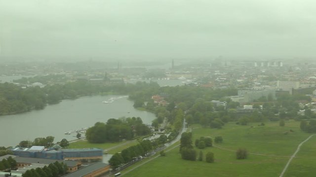Stockholm aerial view from Kaknas Tower with a park at foreground in a cloudy day. Seen through a wet glass.