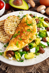 Mushroom, Feta Cheese egg Omelette witch Avocado, vegetables, lettuce, herbs and grilled bread.