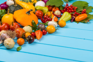 Vegetable background. Fresh peppers, tomatoes, basil, zucchini,pumpkin,spices and seasoning on blue wooden background. Organic food concept. Space for text.