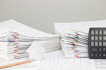 House and pencil have overload document and calculator as background