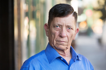 Serious transgender man standing outside