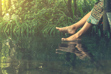 Women's feet in the water plunges feeling freshness