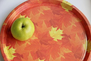 green Apple on a tray with autumn drawing