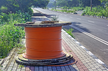Optical fiber cable drum kept at footpath of highway for cabling