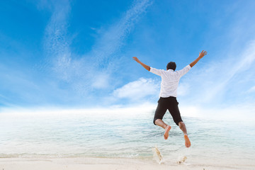 Fototapeta na wymiar Happiness of businessman jumping relax on beautiful sea beach at