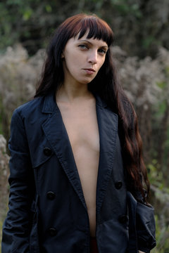 Brunette long haired naked girl in black coat