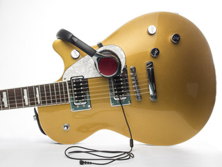 Guitarra y auriculares sobre fondo blanco