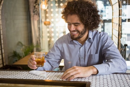 Man having glass of whisky in bar counter