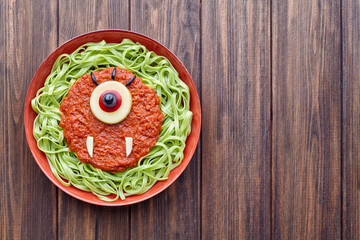 Green spaghetti creative pasta halloween food cyclopes vampire monster meal with fake blood tomato...