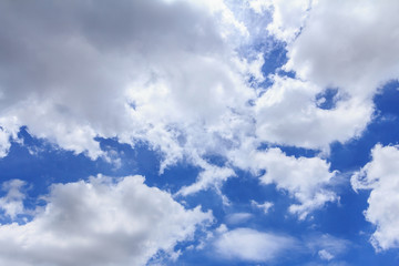 Blue sky background with white clouds and rain clouds. The vast blue sky and clouds sky on sunny day. White fluffy clouds in the blue sky.