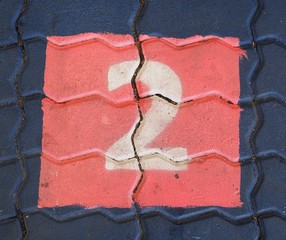 The number two in a square is on the footpath playground.