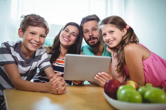 Portrait of smiling family using digital tablet 