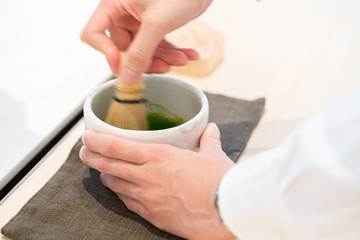 Tea master make matcha tea with tea whisk

